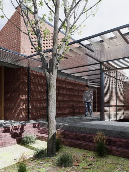 An interior courtyard at Studio Tarai. The design interweaves solid brick volumes with open, naturally lit courts and covered walkways. A tree grows through the center, emphasizing the integration of landscape within the building's footprint.