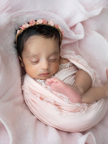 A closer view of the pink bloom setup, focusing on the baby's sweet face and tiny toes peeking out. Absolutely precious.