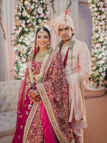 The perfect couple portrait. Her traditional bridal makeup, with its kohl-defined eyes and red lehenga, stands out beautifully, ensuring she is the star of the show.