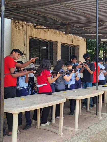 My coaches providing one-on-one guidance to students during a school workshop. This personal attention helps demystify the sport and builds confidence in young, first-time shooters.