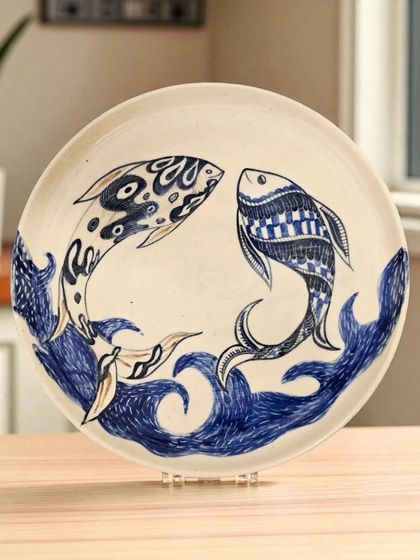 An exquisitely handcrafted plate featuring two fish swimming in harmony. This piece is perfect for enhancing both your wall decor and tabletop aesthetics, bringing a symbol of prosperity into your home.