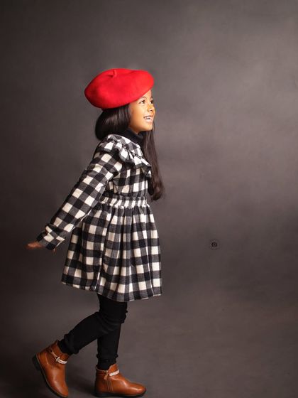 A candid, side-profile shot capturing her joyful expression as she walks through the frame, full of life and energy.