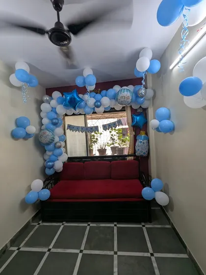 A classic "It's a Boy" welcome home decoration. We created a full balloon arch around the window using shades of blue, white, and silver, instantly making the room feel festive.