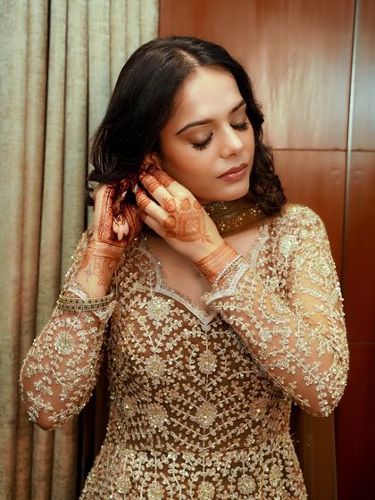 A candid moment of getting ready. Even with her eyes closed, the bronze shimmer on the lids is captivating, showing the richness of the pigments used.