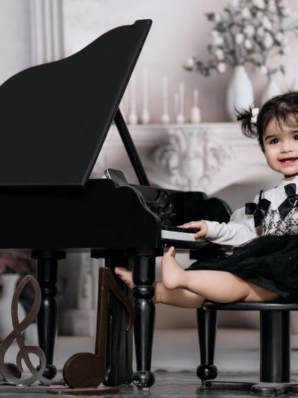 Music fills her soul as she dances across the keys. A stylish girl with pigtails has fun at the piano in our classic studio.