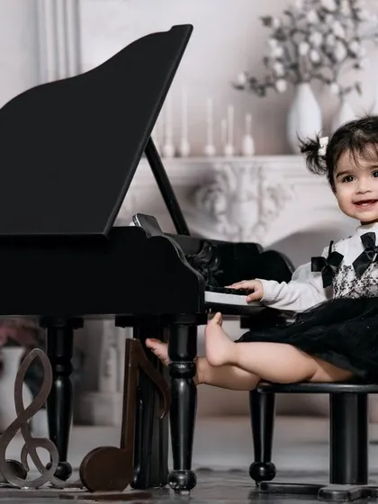 Music fills her soul as she dances across the keys. A stylish girl with pigtails has fun at the piano in our classic studio.