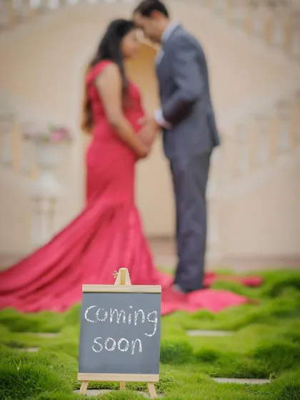 A creative shot focusing on the "Coming Soon" sign, with the couple softly blurred in the background, building anticipation.