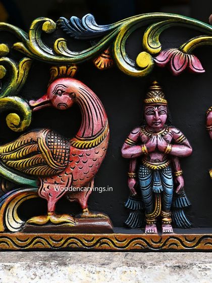 A beautifully carved pink peacock and an attendant deity from the end of the Meenakshi Thirukalyanam panel, framing the grand scene.