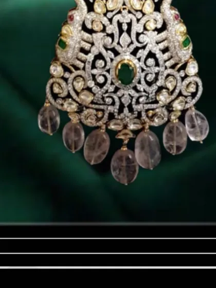 A close-up of the handcrafted pendant from the morganite necklace. You can see the detailed filigree work and the careful setting of each polki, diamond, and gemstone.