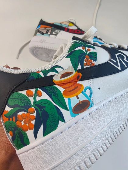 This mismatched pair of Nike Air Forces was customized for a client with all his favourite things. This side features his love for coffee, with coffee plants and a pour-over machine.