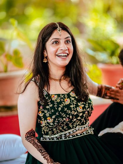 A candid shot of the bride-to-be's happy expression during her Mehendi ceremony.