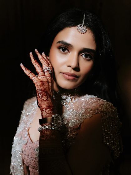 This shot beautifully showcases the intricate henna design alongside the soft, glowing makeup and delicate diamond jewelry.