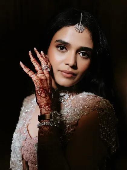 This shot beautifully showcases the intricate henna design alongside the soft and glowing makeup. Every detail comes together to create a perfect and memorable engagement look.