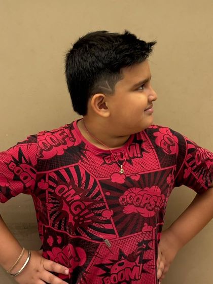 A cool and creative haircut for a young boy, featuring a sharp line design on the side for extra flair.