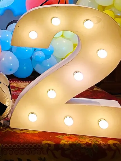 A large light-up number '2' used in a sports-themed birthday celebration.