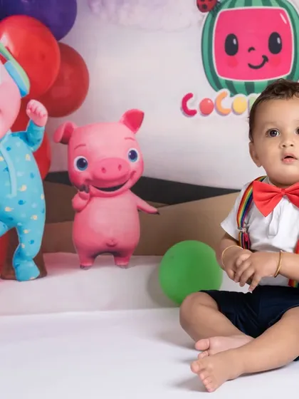 A sweet portrait from a Cocomelon themed sitter session, showing the baby looking curious and engaged with the colorful set.