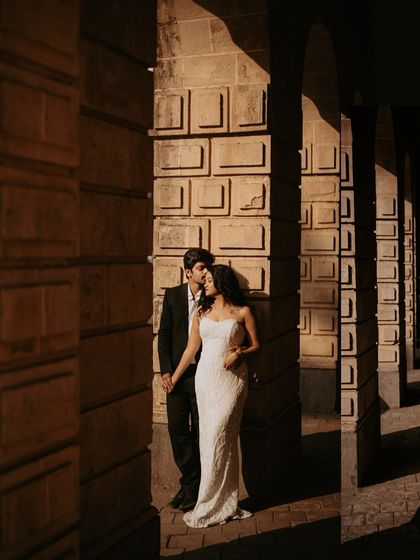 An elegant portrait using the dramatic light and shadows of colonial-era archways in South Mumbai for a timeless feel.