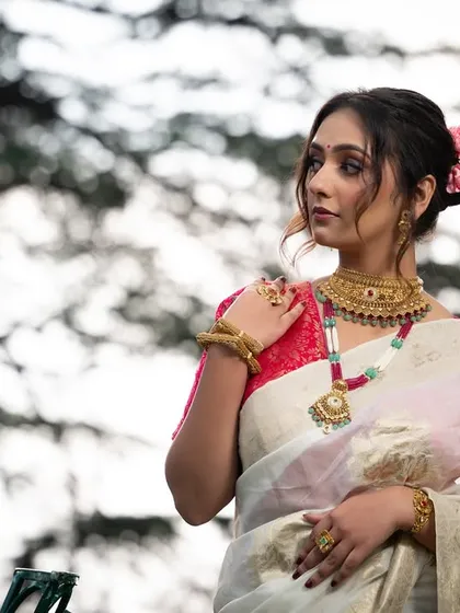 A wider portrait from the gold jewelry shoot, showing the model against a natural backdrop.