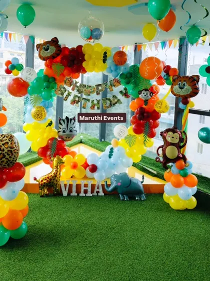 Let's get wild with a fun jungle safari theme! This setup is perfect for little explorers, featuring a colorful balloon arch, friendly animal cutouts like a giraffe and elephant, and a lush green turf floor to complete the jungle vibe.