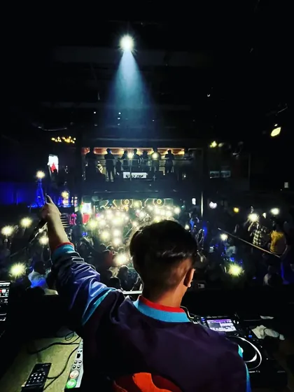 Pointing to the crowd, acknowledging their energy. It's a two-way street, and I feed off their vibe.