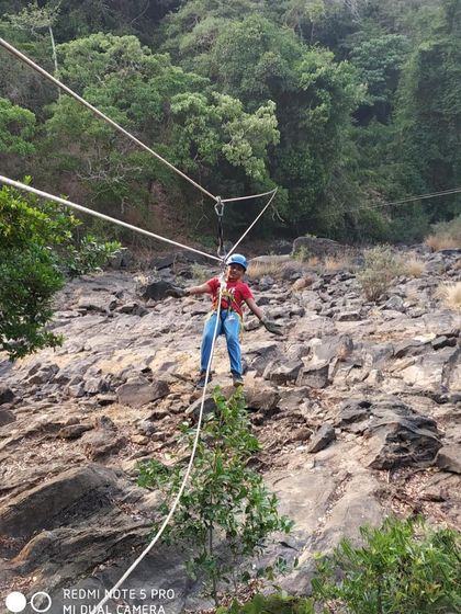 A participant carefully navigates a rope bridge, an activity that tests balance and courage.