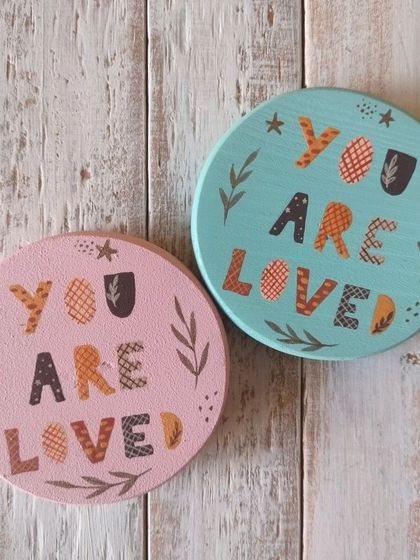 "You are loved." These magnets feature a folksy, patterned font and botanical details, available in soft pink and blue.