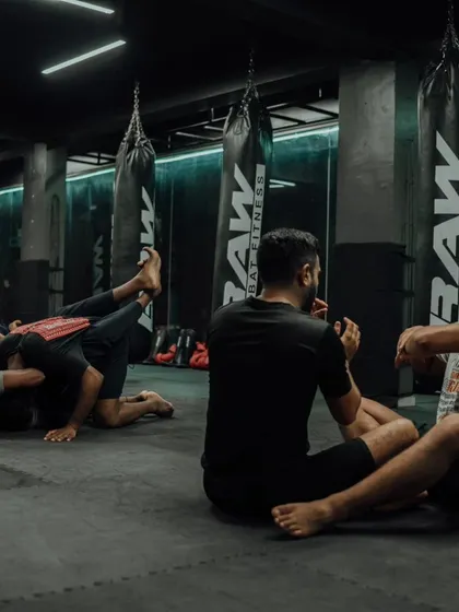 Students sit and discuss techniques after a tough round of grappling.