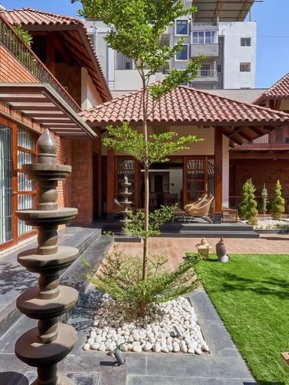 The courtyard is landscaped with a stone water feature and carefully placed trees, blending traditional and contemporary landscape design.