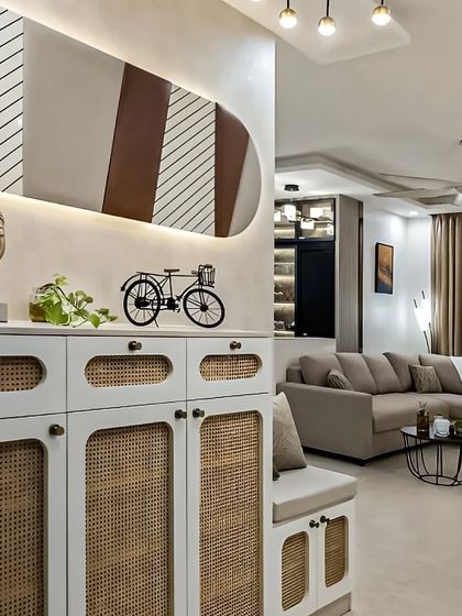 A modern shoe storage cabinet with rattan-paneled doors and a cushioned top that doubles as a bench. This piece adds a touch of bohemian flair to the entryway while keeping it organized.