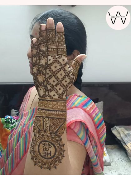 A happy mom-to-be showing off her "He or She" themed baby shower henna.