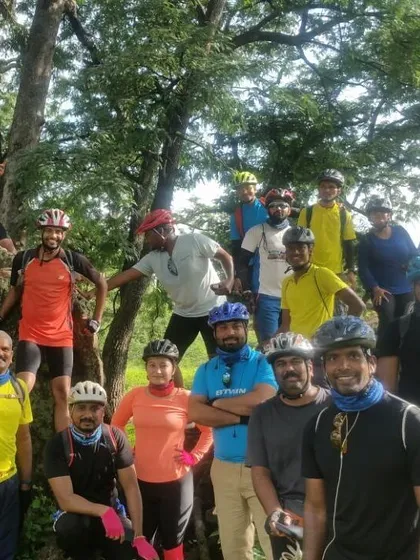 The team posing for a picture in the trees during a break from our Nallur Tamarind Grove ride.