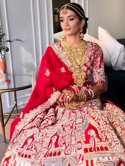 A full-length view of the bride in her magnificent red lehenga, her hair perfectly styled for the grand occasion.