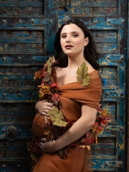 Vintage vibes. This portrait, set against a century-old door, celebrates motherhood with an earthy, autumn-inspired drape.