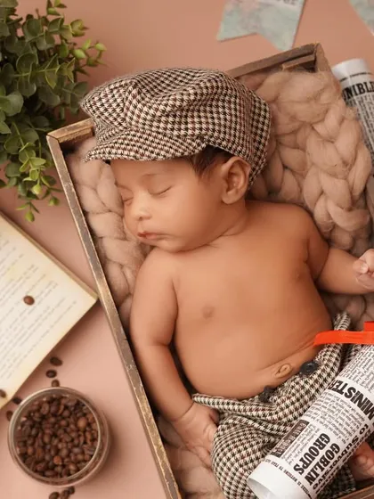 A wider shot of the traveler-themed newborn setup, showing how all the elements come together. The baby is nestled safely in a wooden crate, dreaming of future adventures.