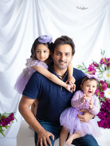 A proud dad with his two daughters. This portrait perfectly captures the special bond between a father and his girls.