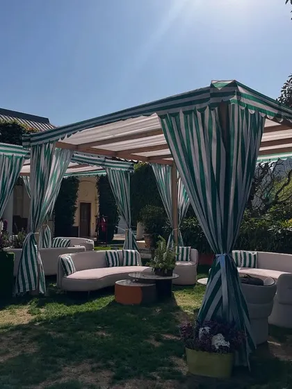 For a boy's first birthday, I created a sophisticated 'Tennis Club' theme, including this elegant cabana lounge with striped green and white curtains.