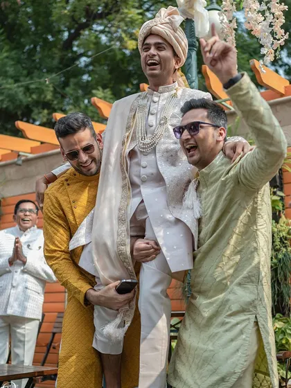 Another angle of the groom's celebratory entrance, with his father looking on proudly.