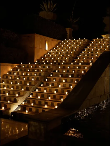 The grand staircase, illuminated by hundreds of candles, creating a breathtaking and dramatic pathway for the all-white Sufi night.