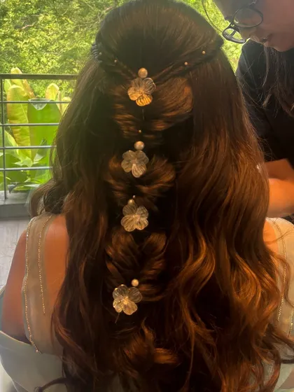 A close-up of the floral bubble braid. The delicate, translucent floral clips add a touch of modern elegance to the style.