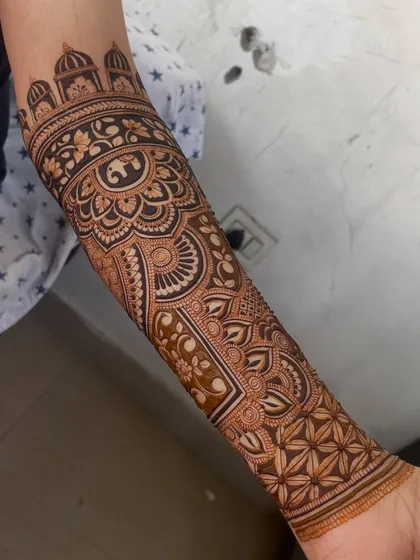 A close-up of a full-arm design, featuring an elephant motif inside a mandala and an architectural dome border.