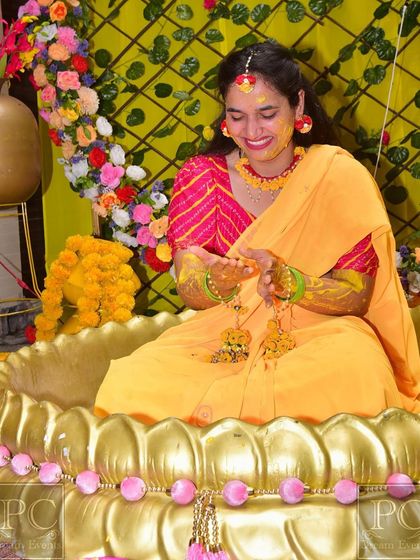 A close-up of the bride during her Haldi ceremony. The vibrant colors of her outfit and the floral decor come together beautifully.
