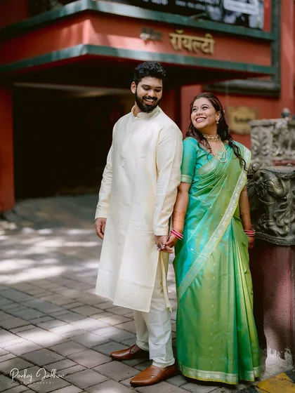 Nidhi and Aditya hold hands, sharing a sweet, knowing glance. This photo captures the simple, heartfelt emotions at the start of their engagement celebration in Pune.