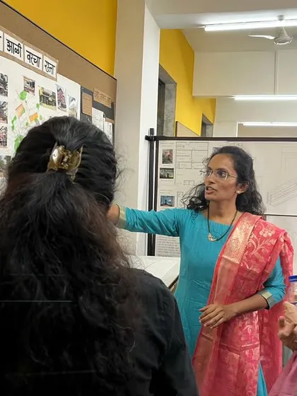 A student presents her research and design board on vernacular architecture. My role is to help them connect their academic research to practical design and artistic expression.