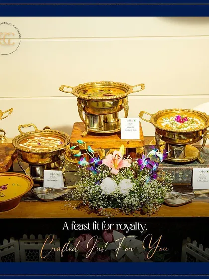 A feast fit for royalty. This image showcases a selection of rich Indian curries presented in ornate brass serving bowls, adorned with fresh flowers for a regal touch.