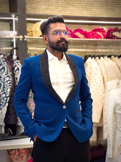 Our client looks sharp in a vibrant royal blue blazer with a black beaded lapel. It's a bold and stylish choice for a cocktail party or sangeet night.