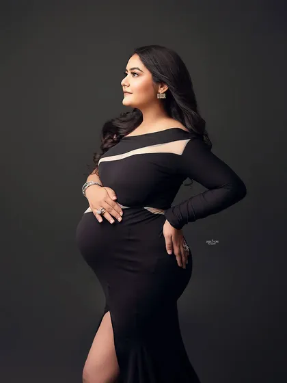 A color version of the same stunning pose, showing the sleek design of the black cutout gown and the mamma's confident glow.