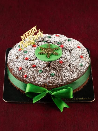 Our rich and fruity rum-soaked Plum Cake, decorated with a green ribbon for Christmas. It's a must-have for any traditional Christmas celebration.