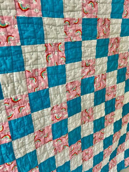 A close-up of the rainbow-themed fabric used in the quilt.