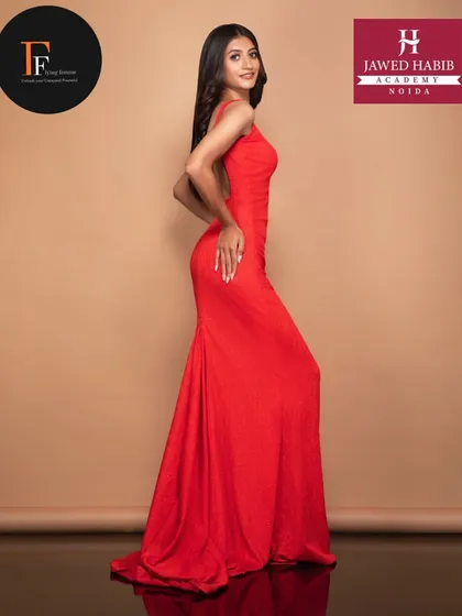 A full length shot of a model in a beautiful red dress, demonstrating the ability to create a cohesive and stunning look for a professional shoot.