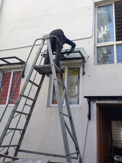 Here you can see my team member installing a custom-fabricated glass and metal awning. These are perfect for protecting windows and doorways from rain and sun without blocking the light.